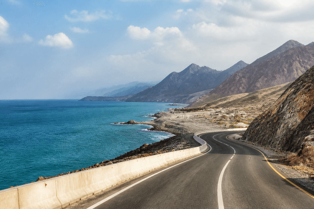 East coast road with Hajar Mountains and ocean
